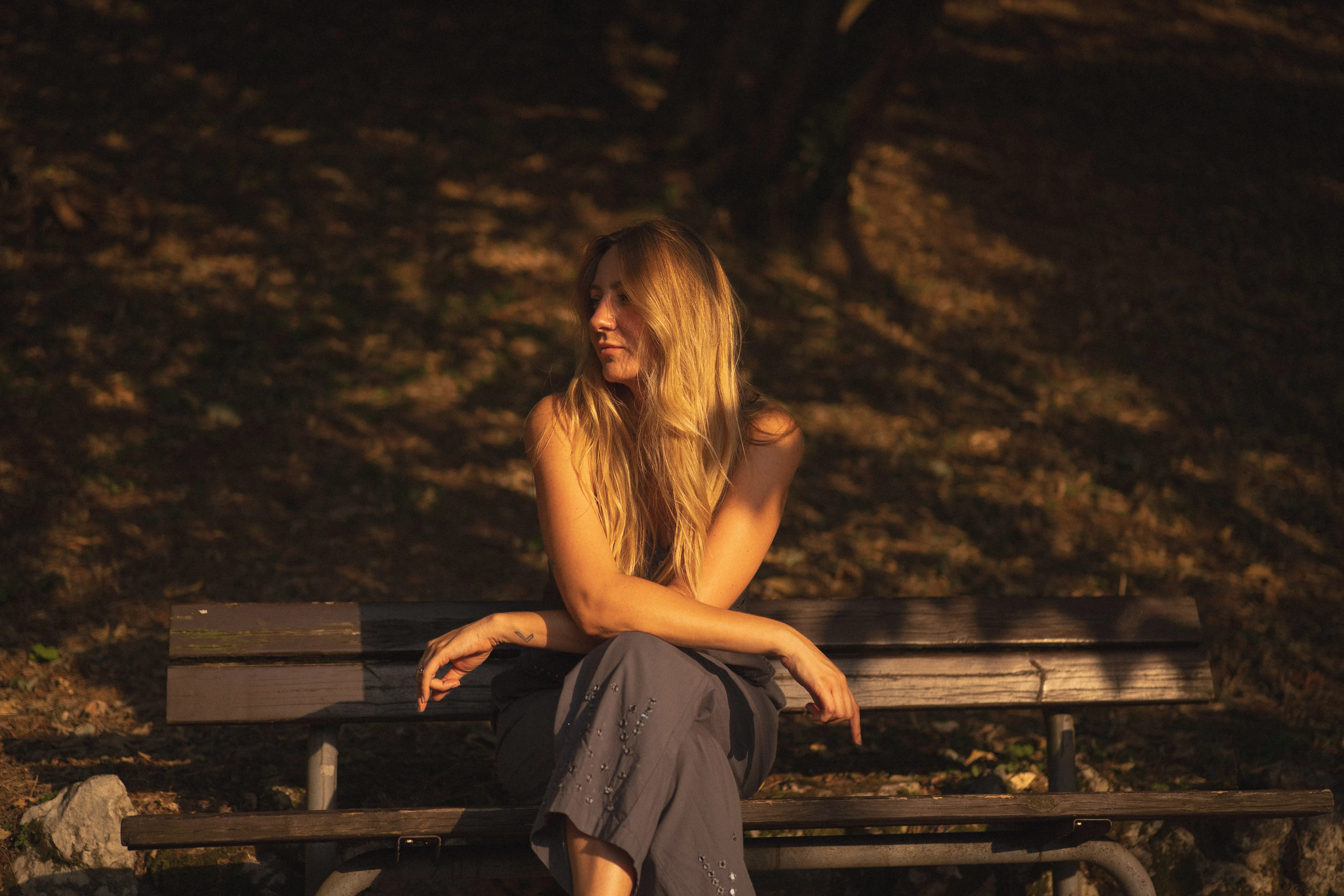 portrait of an italian woman with long blonde hair in le colombare park, verona, italy, at golden hour: eyes closed in the sun, under the leaves, on a park bench (2)