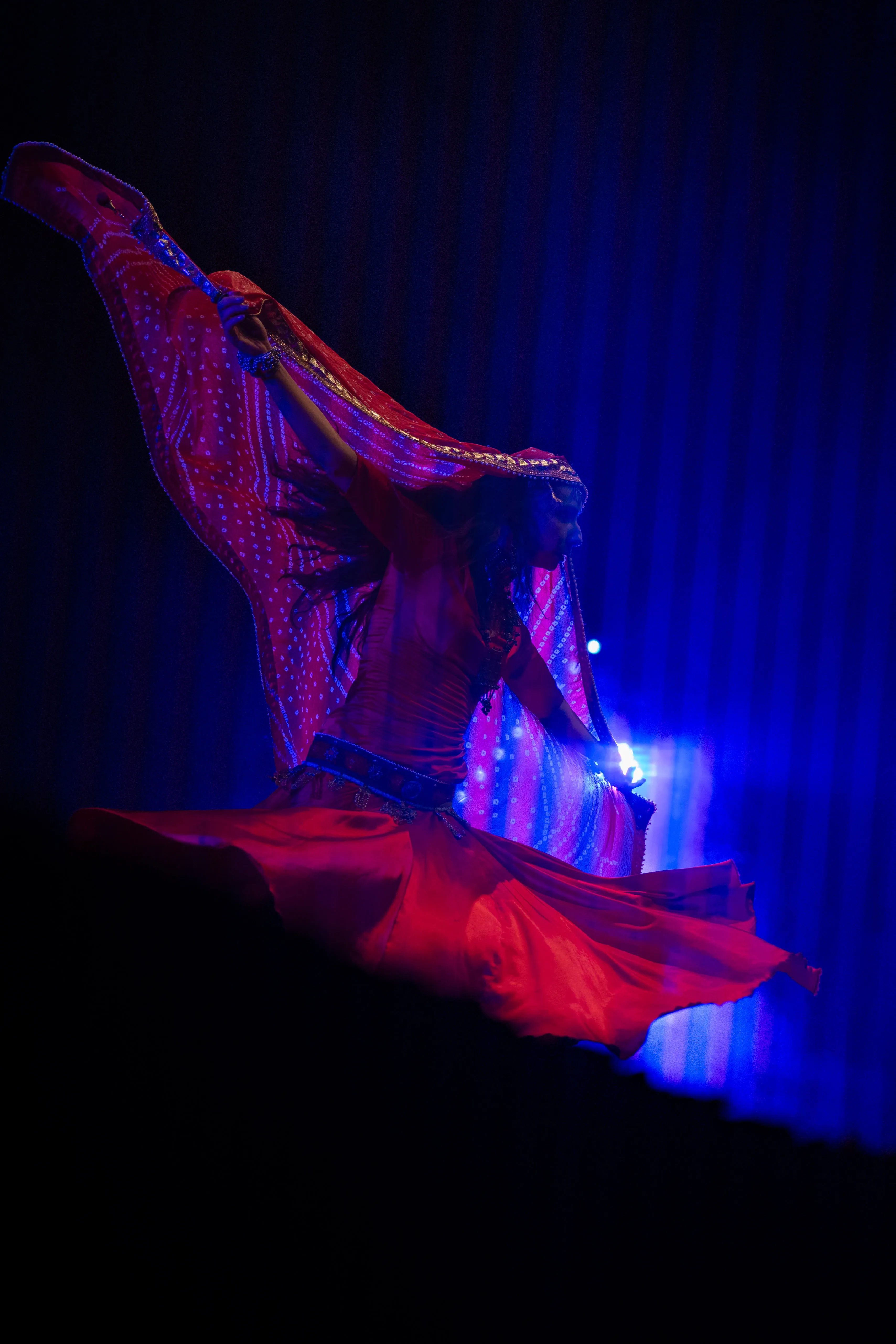 claudia llanos, rajasthani dancer from mexico, in a red dress under blue light and smoke, mexico city (cdmx) (3)